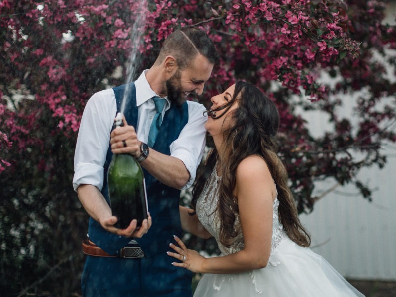 couple popping champange and laughing