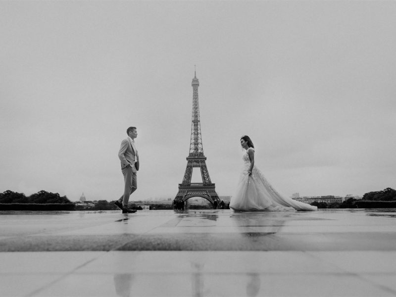 A wedding couple walks towards each other on the Trocadero In Paris, France with the Eiffel Tower in the background